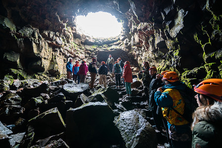 一群游客探索劳法希尔火山洞穴自然固化形成的岩浆图片