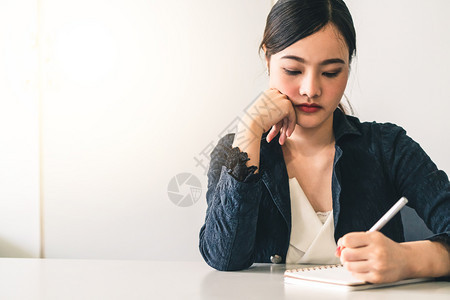 美丽的年轻女士坐在办公桌旁笔记本上写信件内容作和秘书职务概念背景图片