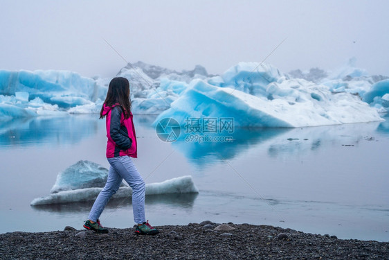 女探险家在阿拉斯加冰岛沙滩行走图片