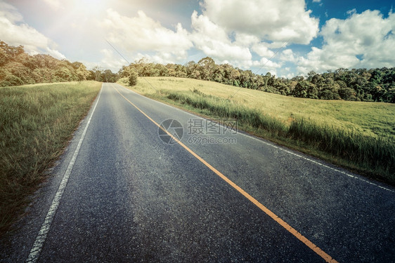 夏日蓝天白云下穿过绿草地的高速公路图片