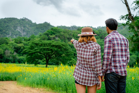 西班牙春天快乐的情侣在山上草地度过浪漫旅行和蜜月背景