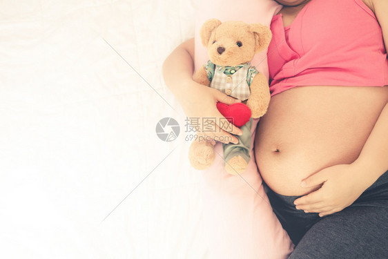 幸福的孕妇睡在家中卧室里休息图片