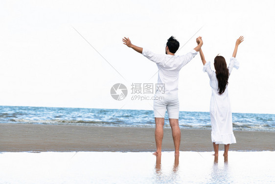 情侣在沙滩上欣赏海浪图片