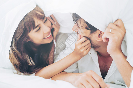 快乐的年轻夫妇在早晨醒来后家庭卧室放松图片