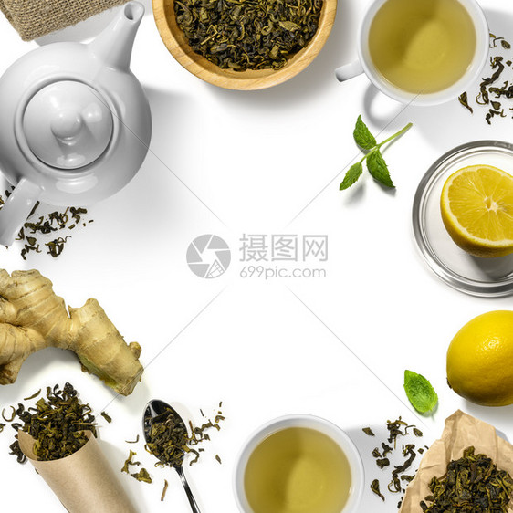 白色背景下的绿茶叶和茶壶茶具图片