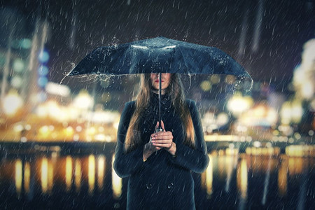 在下雨的晚上撑着黑色雨伞的女人图片