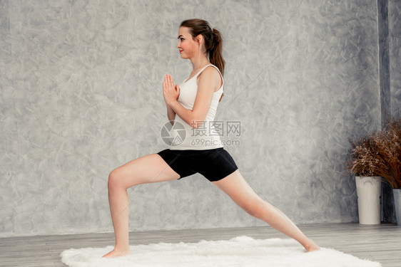 年轻美女在客厅做瑜伽锻炼和放松图片
