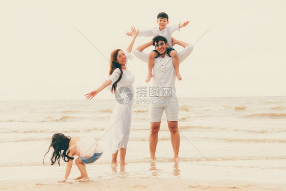 父母和孩子暑假在热带沙滩上度假图片