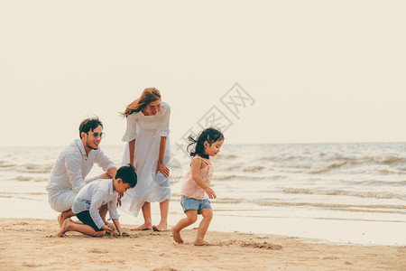 夏天幸福的家庭父母和儿女在热带沙滩上度假背景图片