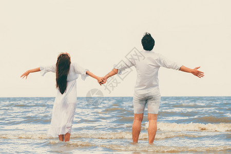情侣展开双手拥抱海滩背景图片