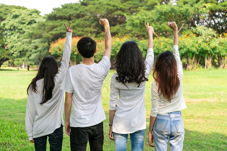 快乐的男女青年学生在校园举手庆祝图片