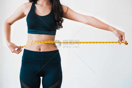 正在测量腰围的年轻女子图片