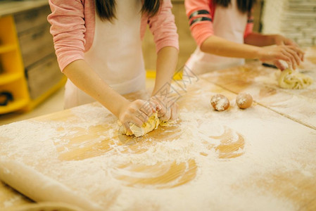 两个小女孩揉面团在厨房做饼干有趣的面包师图片