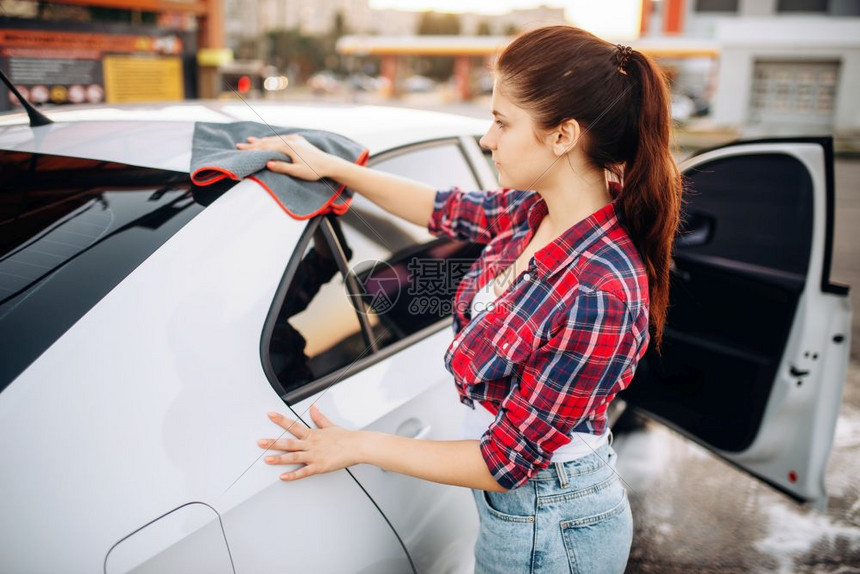 妇女洗完车后用布涤擦车图片