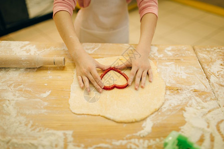 穿围裙做饭的小女孩在厨房做饼干图片