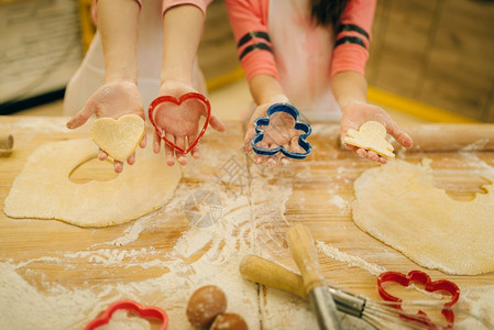 两个小女厨师拿着饼干剪做造型图片