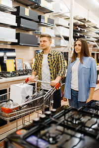 男女在市场上购买家用电器夫妇在子商店里持有搅拌机图片