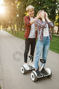 在公园使用平衡车的年轻夫妇图片
