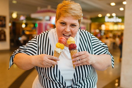 胖女人在快餐商场厅吃两个冰淇淋超重女吃冰淇淋肥胖症图片