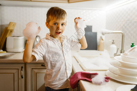 一个小男孩在厨房玩泡沫图片