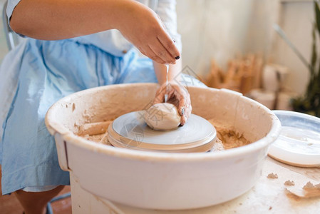 女陶器手在车轮上工作妇女造陶器手工瓷艺品用粘土制成的陶器图片