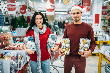 情侣在商场拿着圣诞玩具球图片