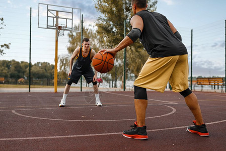 两名篮球运动员在室外球场上练习图片