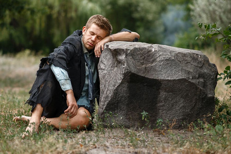 破产的男性商人沉睡在岩石上图片素材