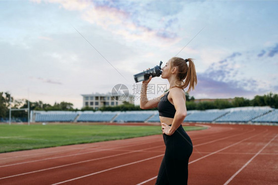 女女运动员在体育场穿着运动服喝水图片