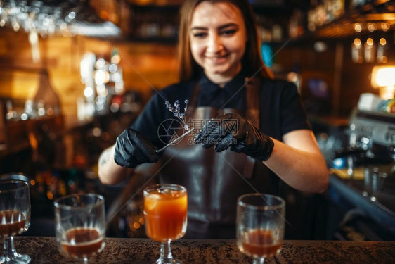 拿着一杯鸡尾酒的女酒保图片