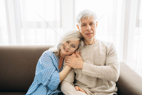 成年夫妻坐在沙发上拥抱图片