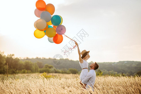 夏天情侣在田里的手拉热气球图片