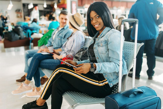 携带行李等待出发的黑人女游客图片