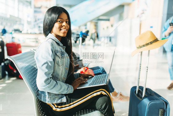 机场携带笔记本电脑等待离境的女游客图片