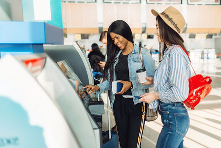 2名女旅行者在机场的Atm取现金图片