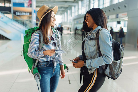 两名背着背包的女游客在国际机场候机厅图片