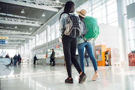 携带背包的女游客行走在国际机场等候区图片