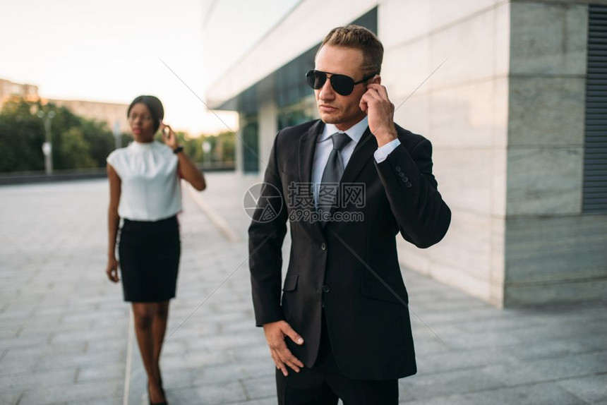 带着太阳眼镜的警卫和黑人女商人图片