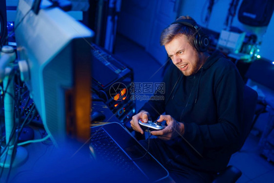 玩游戏的男家玩棍在台式电脑游戏中玩生活方式网络体育场电脑游戏有亮光的游戏玩家在他的房间里图片