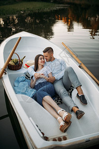 夫妻躺在湖边船上图片