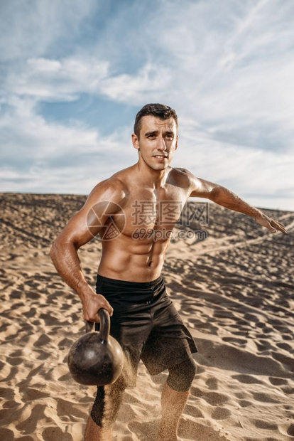 男运动员在阳光明媚的沙漠中锻炼图片