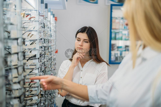 女士在眼镜店挑选眼镜图片