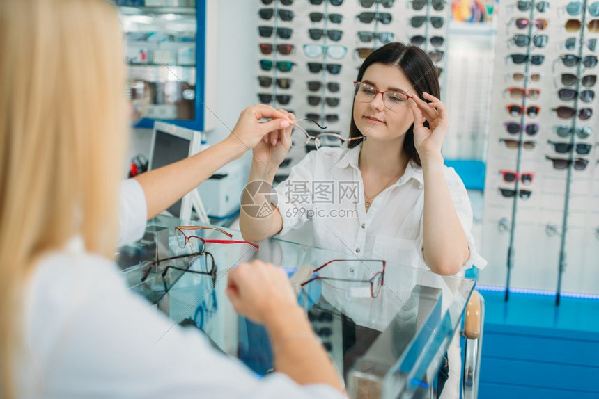 女士在眼镜店挑选眼镜图片