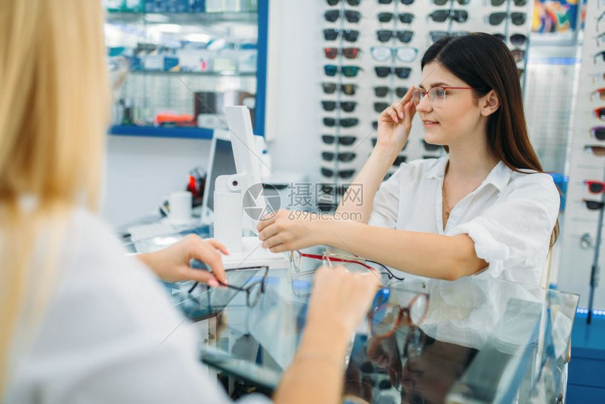 女士在眼镜店挑选眼镜图片