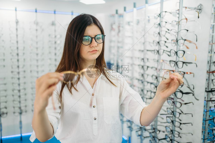 女士在眼镜店挑选眼镜图片