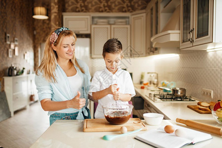 可爱的女人和小孩在厨房准备甜点玩得开心图片