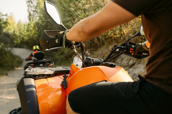 驾驶员在森林公路骑四轮摩托车图片