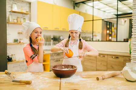 儿童厨师做蛋糕小女孩把橘涂到碗里图片