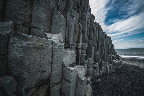 位于南冰地vikmyrdalin村附近的冰地黑沙滩上美丽和独特火山岩层六角圆柱岩吸引了访问冰地的游客图片