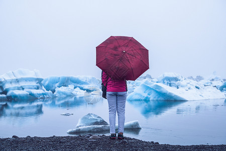女游客撑着伞观看冰川图片